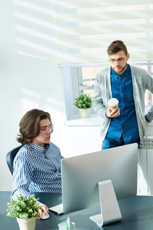 Dos personas alrededor de un ordenador.